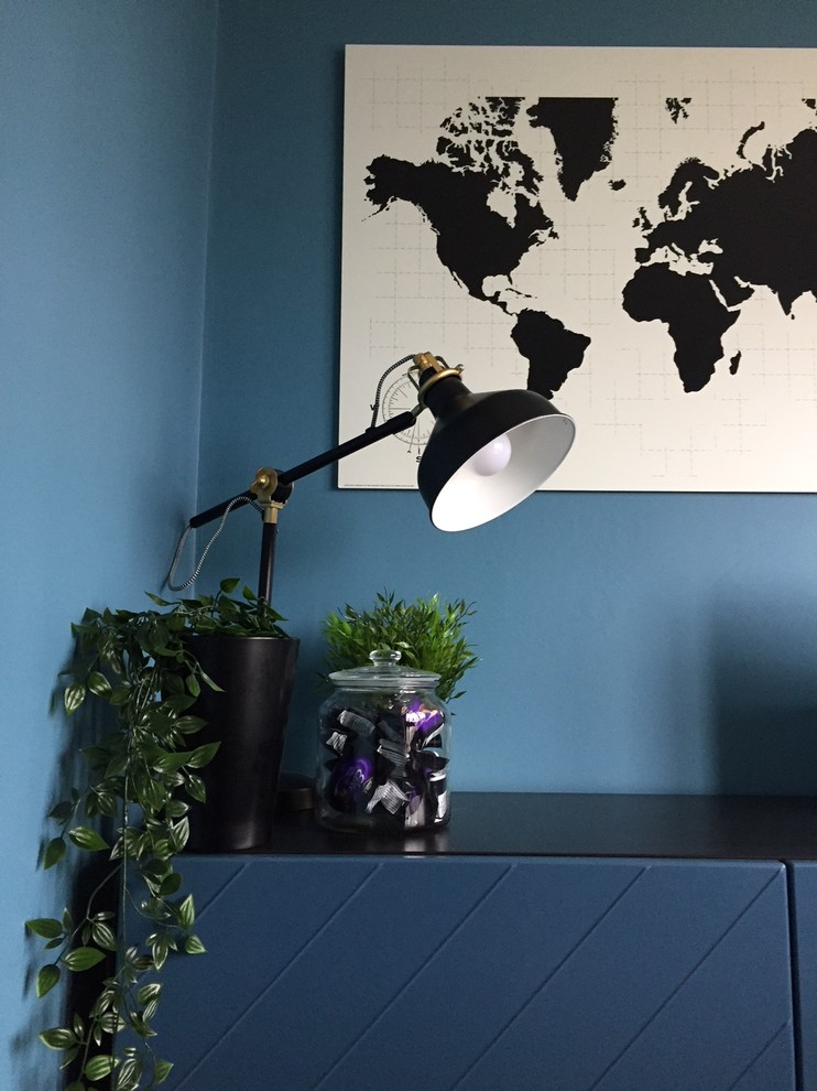 Diseño de despacho actual pequeño con paredes azules, suelo laminado, escritorio independiente y suelo amarillo