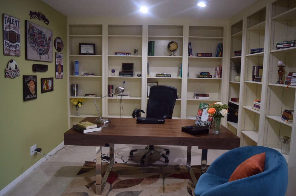 This is an example of a small contemporary study in Houston with beige walls, carpet, a freestanding desk and beige floors.