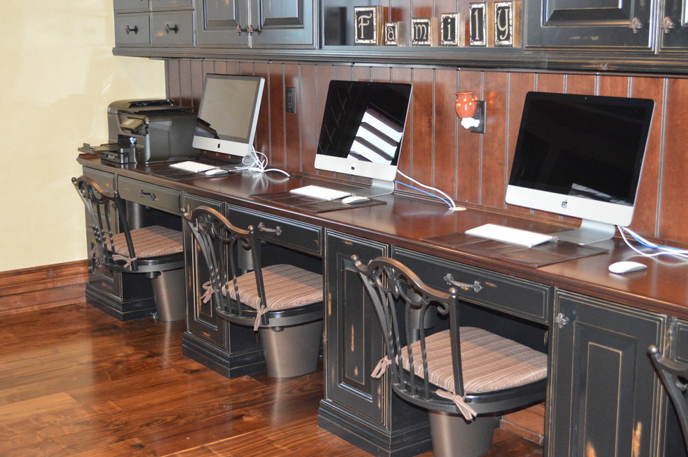 Imagen de despacho clásico grande con suelo de madera en tonos medios, escritorio empotrado y paredes beige