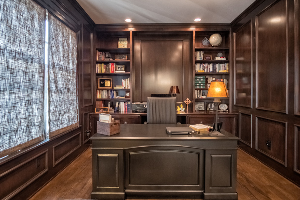 Diseño de despacho clásico de tamaño medio sin chimenea con paredes marrones, suelo de madera oscura y escritorio independiente