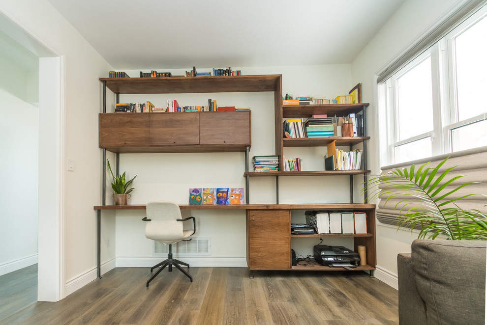 Inspiration för mellanstora moderna hemmabibliotek, med vita väggar, mellanmörkt trägolv, ett inbyggt skrivbord och grått golv