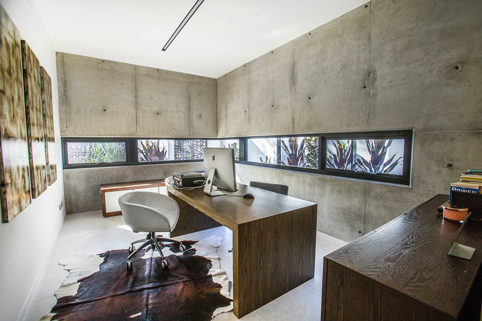 Imagen de despacho moderno grande con paredes grises, suelo de baldosas de porcelana y escritorio independiente