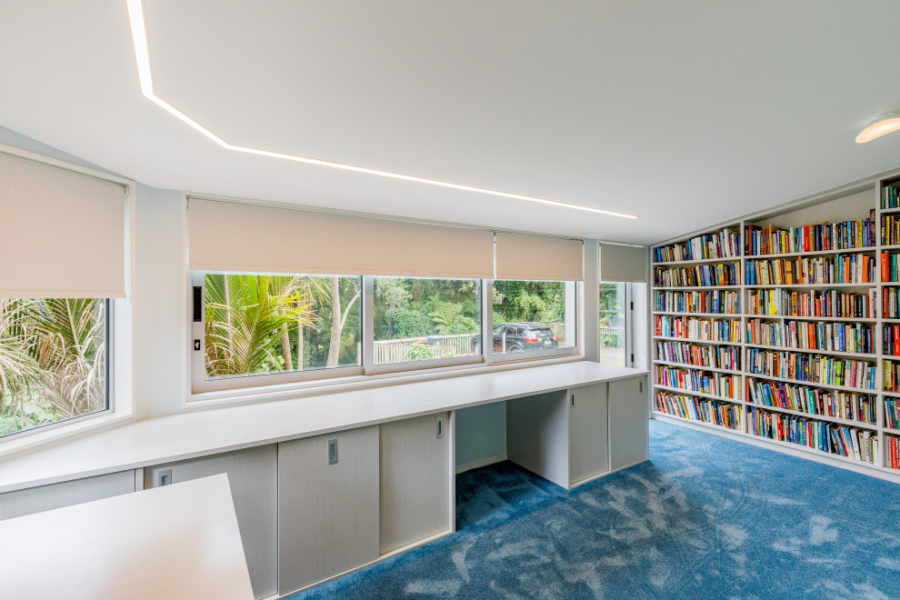 Mittelgroßes Modernes Arbeitszimmer mit Arbeitsplatz, blauer Wandfarbe, Teppichboden und blauem Boden in Auckland