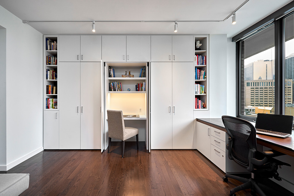 Ispirazione per un grande ufficio minimalista con pareti bianche, parquet scuro, nessun camino, scrivania incassata e pavimento marrone