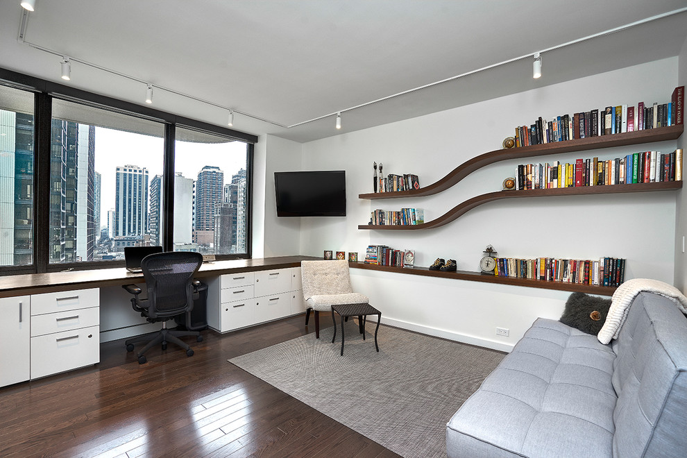 Large minimalist built-in desk dark wood floor and brown floor study room photo in Chicago with white walls and no fireplace