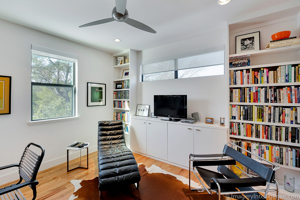 Ejemplo de despacho actual de tamaño medio con paredes blancas, suelo de madera en tonos medios y escritorio independiente