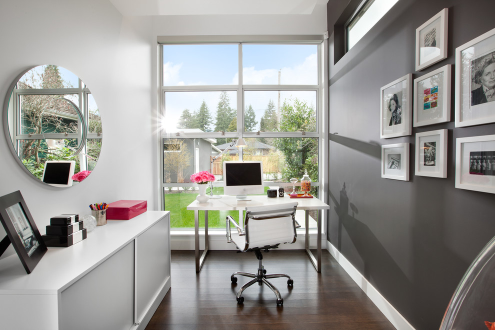 Trendy freestanding desk dark wood floor home office photo in Vancouver with gray walls