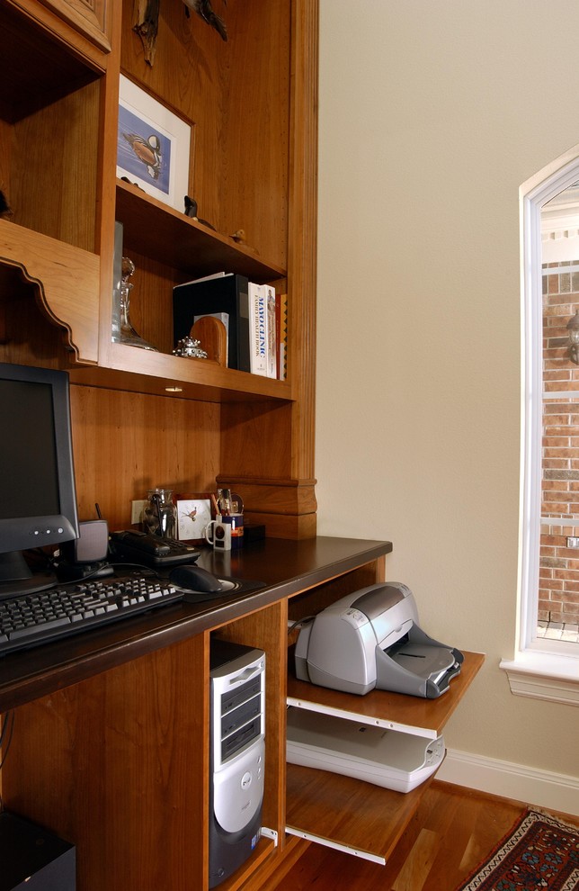 Imagen de despacho tradicional grande con paredes blancas, suelo de madera en tonos medios y escritorio independiente