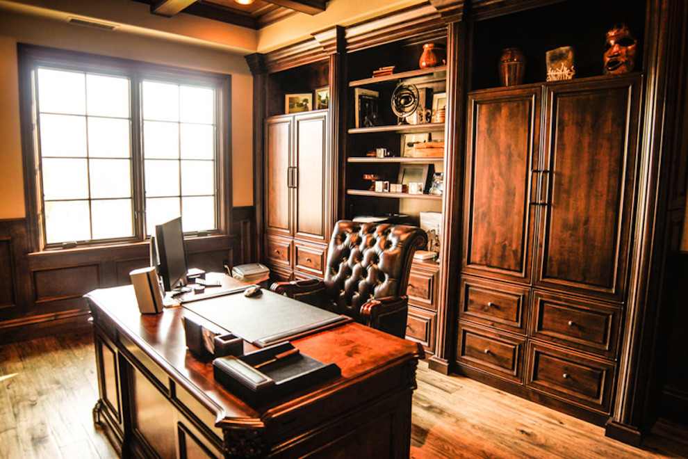 Cette photo montre un grand bureau chic avec un mur beige, un sol en bois brun, un bureau indépendant et un sol marron.