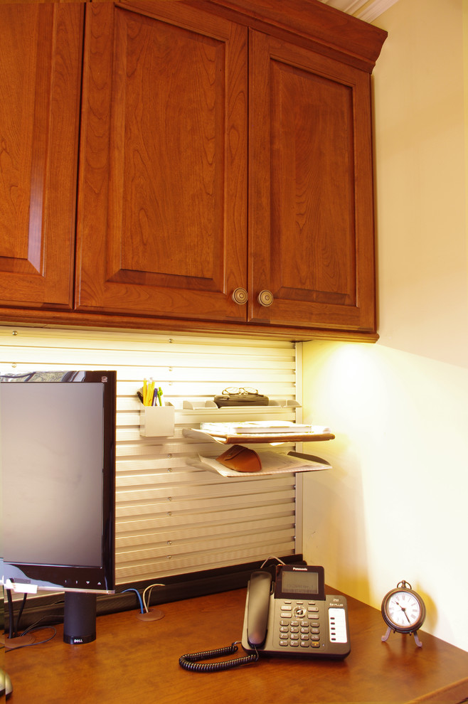 Inspiration för små klassiska arbetsrum, med mellanmörkt trägolv, ett inbyggt skrivbord och gula väggar