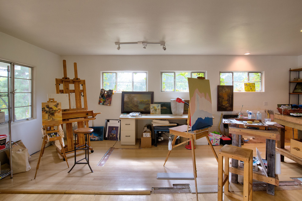 Inredning av ett klassiskt stort hemmastudio, med beige väggar, ljust trägolv och brunt golv