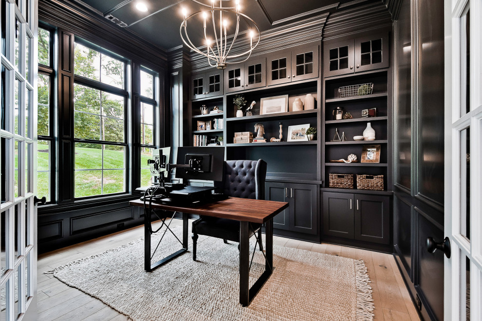 Mittelgroßes Rustikales Arbeitszimmer mit Arbeitsplatz, schwarzer Wandfarbe, hellem Holzboden, freistehendem Schreibtisch, Kassettendecke und Holzwänden in Little Rock