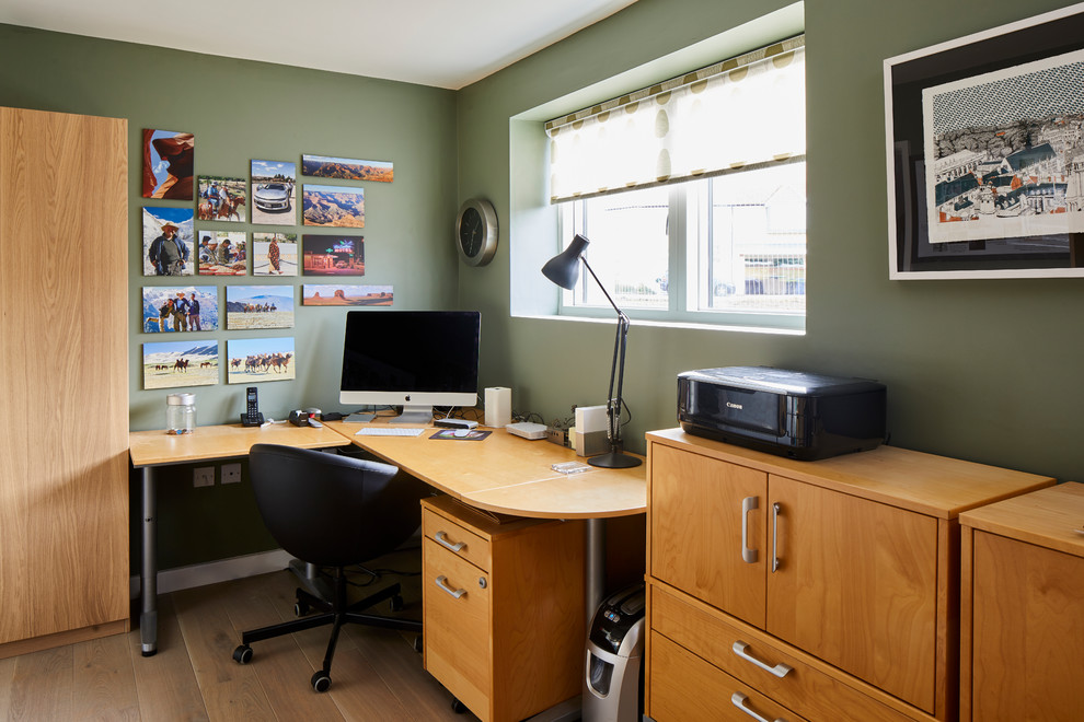 Home office - modern light wood floor and brown floor home office idea in Other with green walls