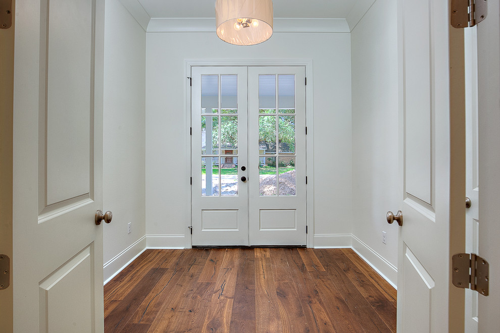 Photo of a small country study in New Orleans with white walls, medium hardwood flooring and brown floors.