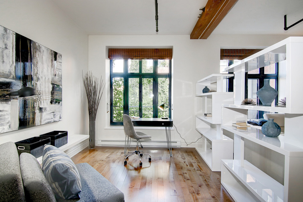 Foto på ett litet funkis hemmastudio, med vita väggar, mellanmörkt trägolv, en standard öppen spis, en spiselkrans i gips, ett fristående skrivbord och brunt golv