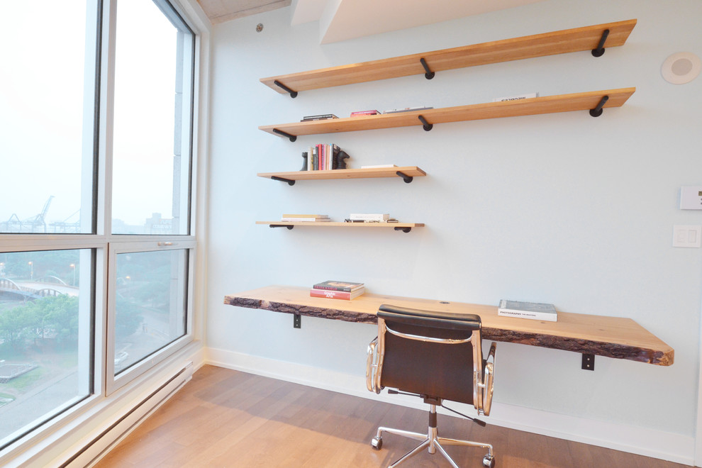 Inspiration pour un petit bureau chalet avec un mur bleu, un sol en bois brun, un bureau intégré et un sol marron.