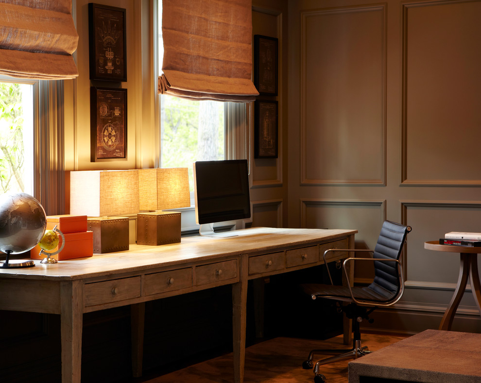 Geräumiges Klassisches Arbeitszimmer ohne Kamin mit Arbeitsplatz, grauer Wandfarbe, braunem Holzboden und freistehendem Schreibtisch in New York