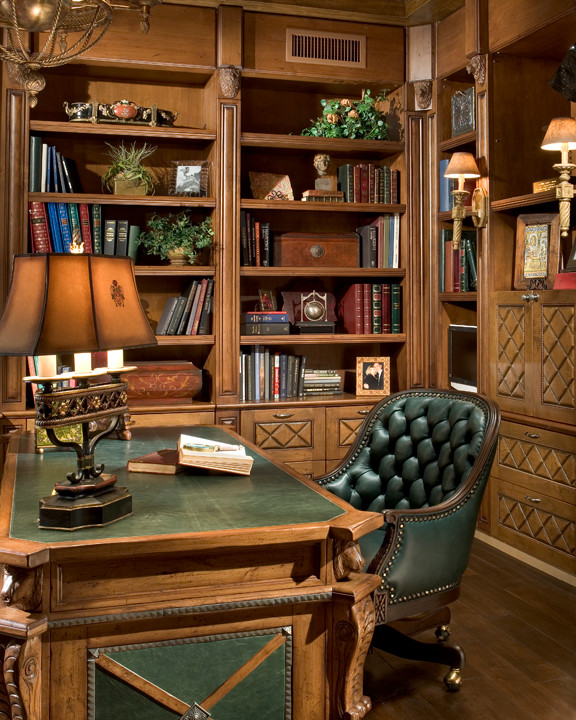 Ejemplo de despacho mediterráneo grande con biblioteca, paredes marrones, suelo de madera oscura, escritorio independiente y suelo marrón