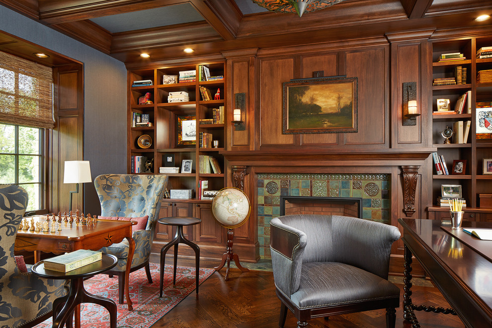 ミネアポリスにあるトラディショナルスタイルのおしゃれなホームオフィス・書斎 (グレーの壁、無垢フローリング、標準型暖炉、タイルの暖炉まわり、自立型机、茶色い床) の写真