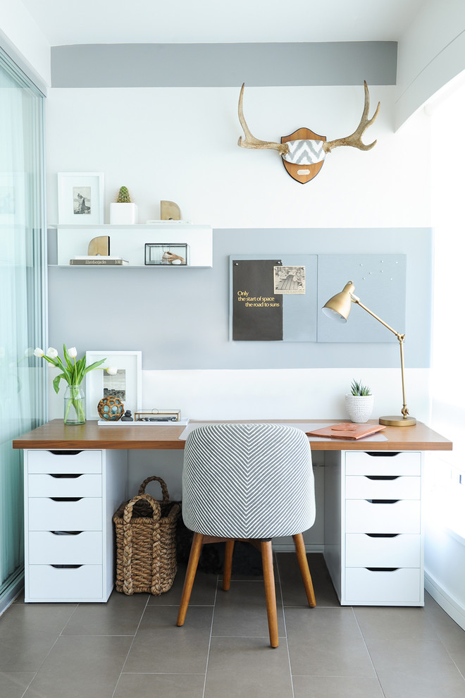 На фото: рабочее место в стиле неоклассика (современная классика) с серыми стенами и отдельно стоящим рабочим столом
