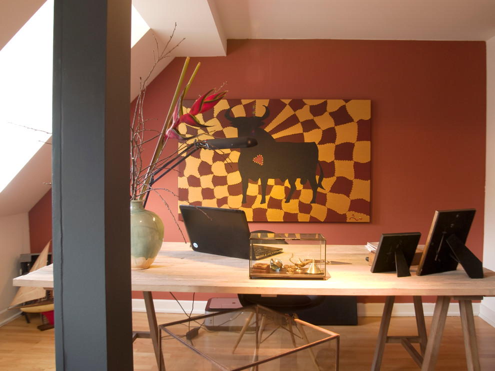 Idee per uno studio eclettico con pareti rosse, pavimento in legno massello medio e scrivania autoportante
