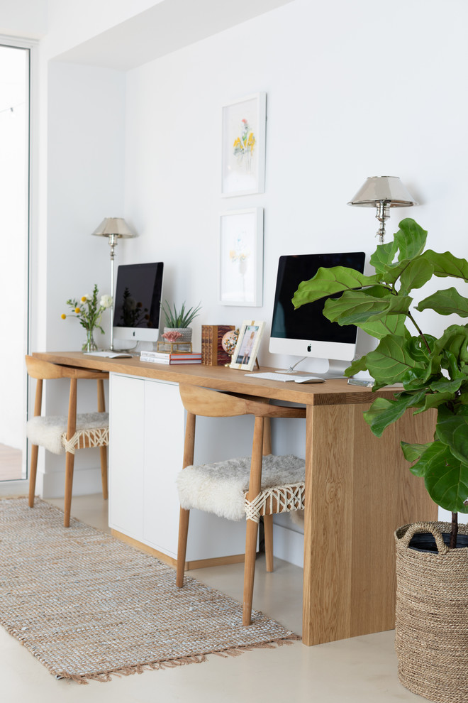 Ispirazione per un ufficio stile marino di medie dimensioni con pareti bianche, pavimento in cemento, scrivania autoportante e pavimento beige