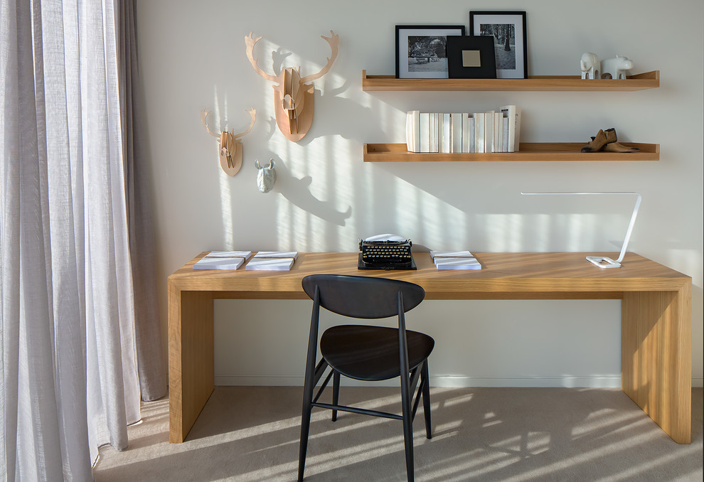 Immagine di un ufficio minimal di medie dimensioni con scrivania autoportante, pareti bianche e moquette