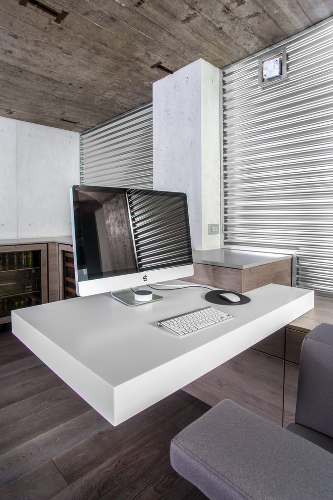 Imagen de estudio minimalista de tamaño medio con paredes blancas, suelo de madera oscura y escritorio empotrado