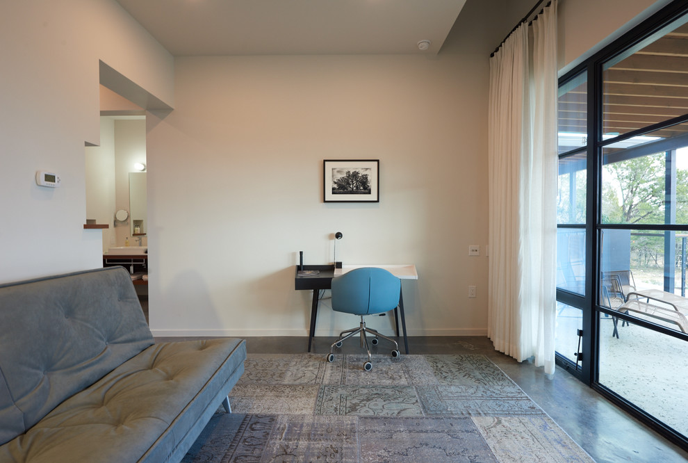 Пример оригинального дизайна: кабинет среднего размера в стиле модернизм с белыми стенами, бетонным полом, встроенным рабочим столом и серым полом без камина