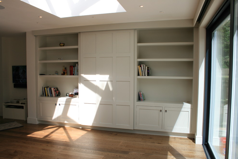 Photo of a medium sized classic study in London with white walls, dark hardwood flooring and a built-in desk.