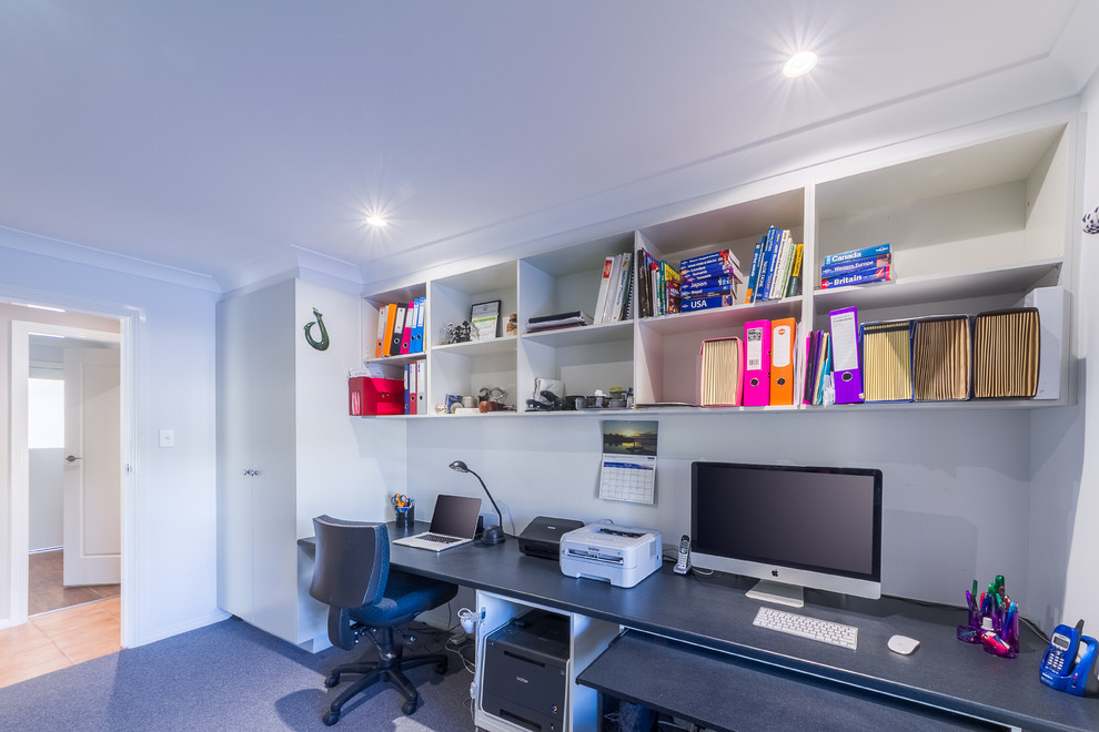 Imagen de despacho contemporáneo de tamaño medio con paredes blancas, moqueta y escritorio empotrado