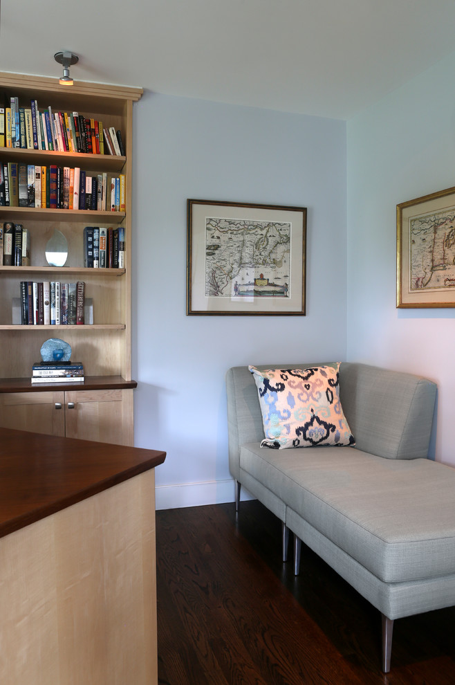 Immagine di uno studio moderno di medie dimensioni con pareti blu, parquet scuro, scrivania incassata, libreria e pavimento marrone