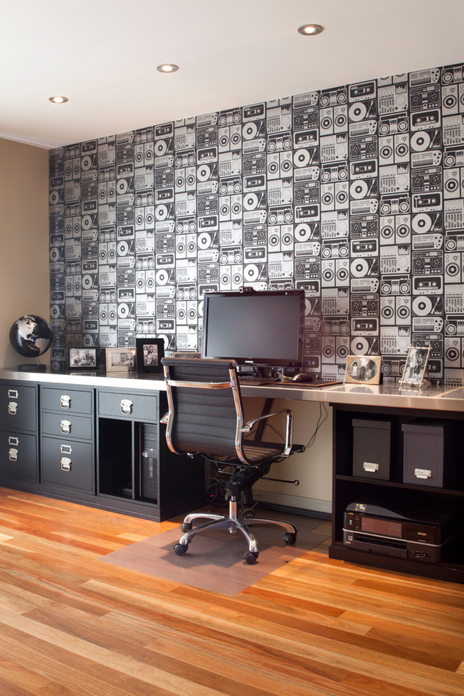 Ejemplo de despacho actual con paredes multicolor, suelo de madera en tonos medios y escritorio empotrado