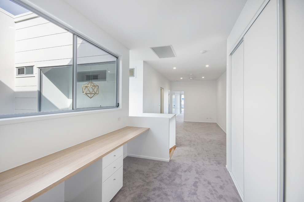 Mittelgroßes Modernes Arbeitszimmer mit Arbeitsplatz, weißer Wandfarbe, Teppichboden, Einbau-Schreibtisch und grauem Boden in Sunshine Coast