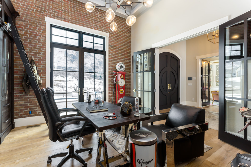 This is an example of a large traditional study in Salt Lake City with red walls, light hardwood flooring, no fireplace, a freestanding desk and beige floors.