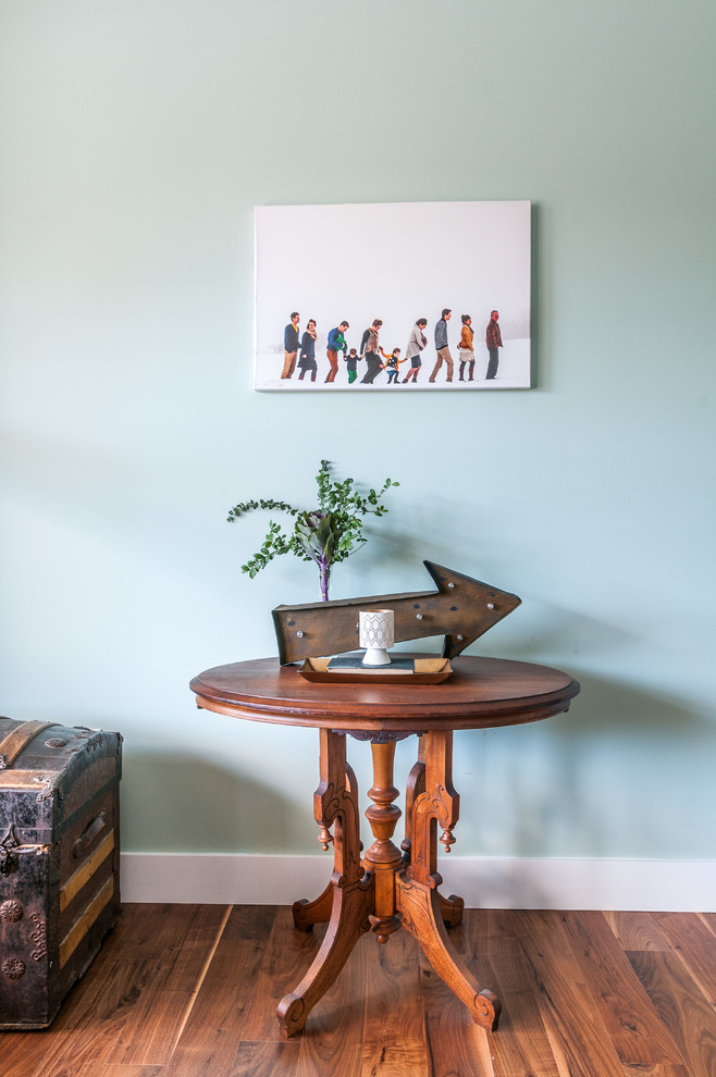 Ejemplo de despacho de tamaño medio con paredes azules, suelo de madera en tonos medios y escritorio independiente
