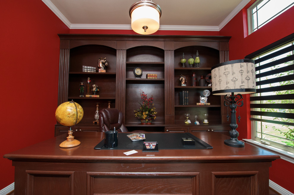 Idéer för ett mellanstort klassiskt hemmabibliotek, med röda väggar, mörkt trägolv och ett fristående skrivbord