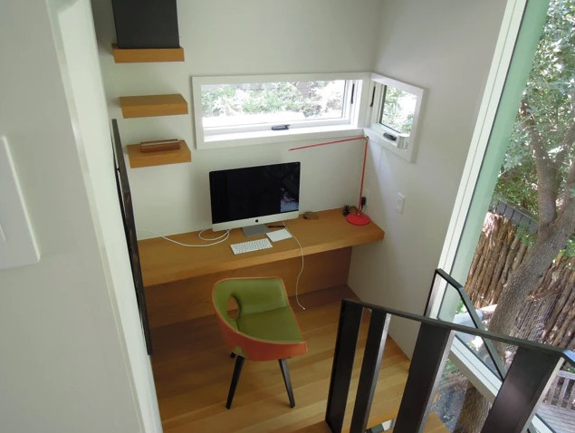 Diseño de despacho contemporáneo pequeño sin chimenea con paredes blancas, suelo de madera clara, escritorio empotrado y suelo marrón