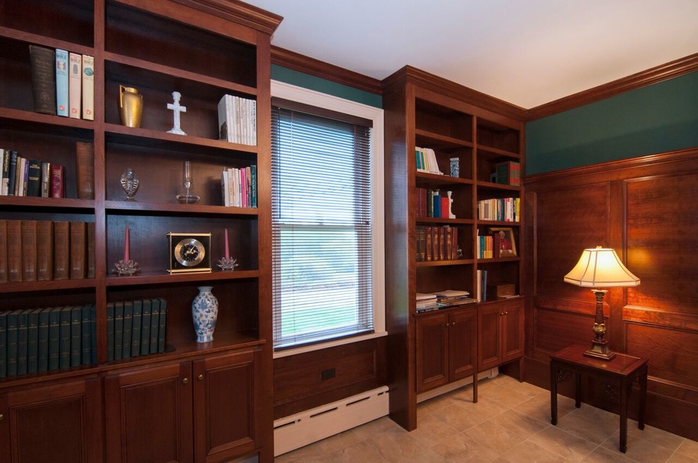 Foto de despacho tradicional de tamaño medio sin chimenea con paredes verdes, escritorio independiente, biblioteca, suelo de travertino y suelo beige