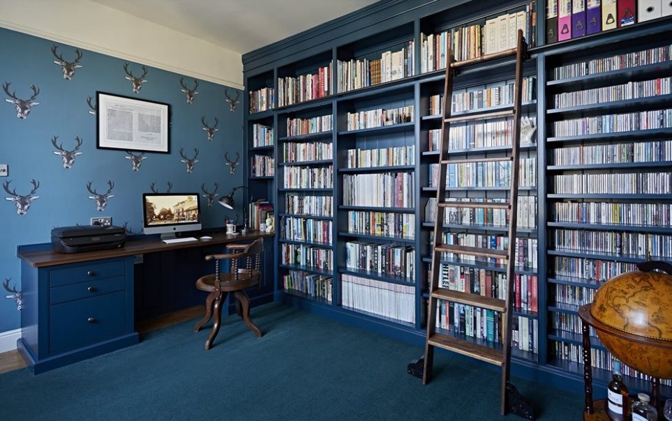 Immagine di uno studio classico di medie dimensioni con libreria e pareti blu