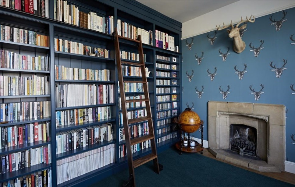 Immagine di uno studio chic di medie dimensioni con libreria e pareti blu