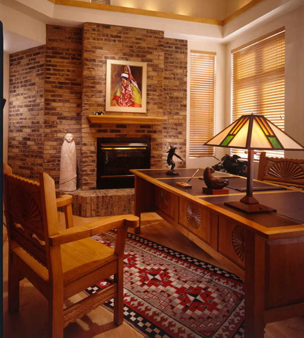 Idée de décoration pour un bureau sud-ouest américain de taille moyenne avec un mur multicolore, un sol en bois brun, une cheminée standard, un manteau de cheminée en brique, un bureau indépendant et un sol marron.