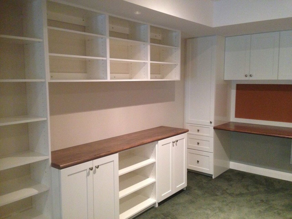 Ejemplo de despacho clásico renovado de tamaño medio con paredes beige, moqueta y escritorio empotrado