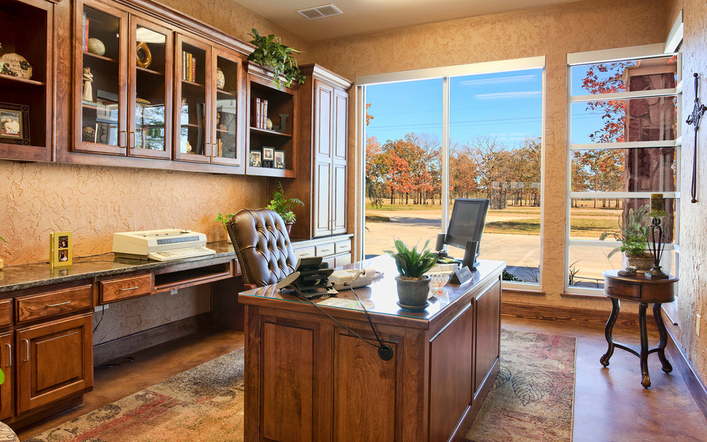 Cette photo montre un bureau craftsman de taille moyenne avec un mur beige, sol en béton ciré, aucune cheminée, un bureau indépendant et un sol marron.