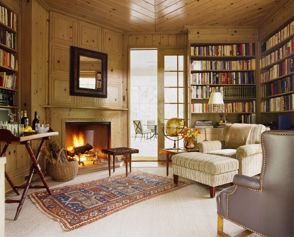 Exempel på ett klassiskt hemmabibliotek, med heltäckningsmatta, en öppen hörnspis och en spiselkrans i trä