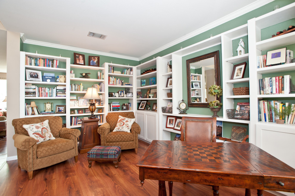 Mittelgroßes Klassisches Arbeitszimmer ohne Kamin mit grüner Wandfarbe, Arbeitsplatz, braunem Holzboden und freistehendem Schreibtisch in Austin