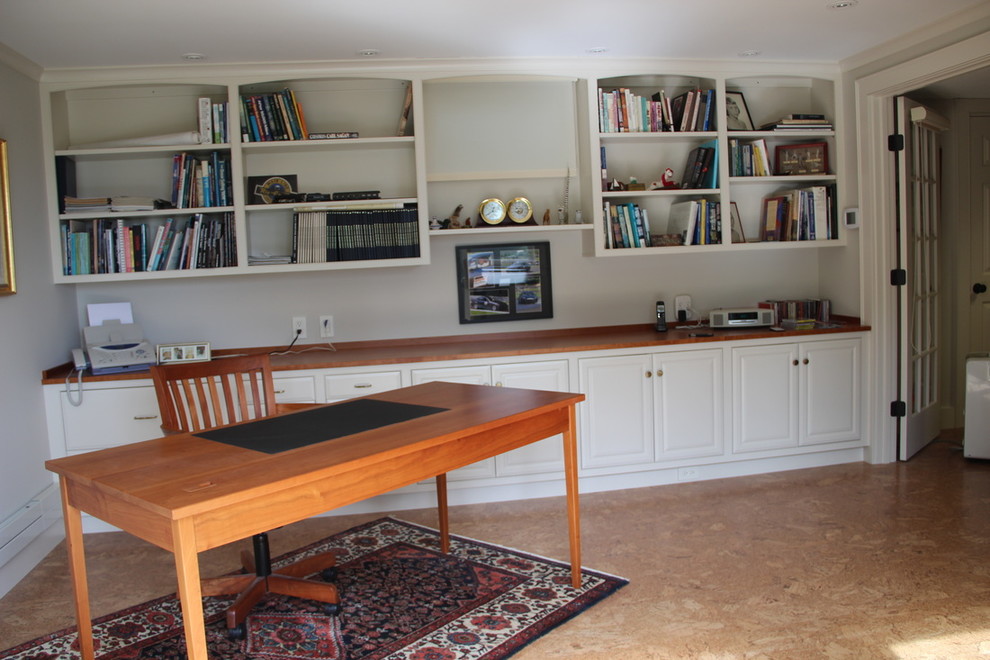 Großes Klassisches Lesezimmer ohne Kamin mit weißer Wandfarbe, freistehendem Schreibtisch, Korkboden und braunem Boden in Sonstige