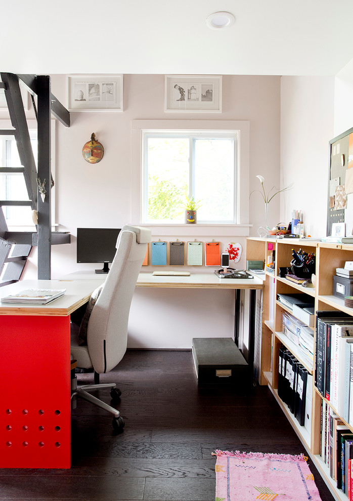 Cette image montre un petit bureau minimaliste avec une bibliothèque ou un coin lecture, parquet foncé, un bureau intégré et un mur blanc.