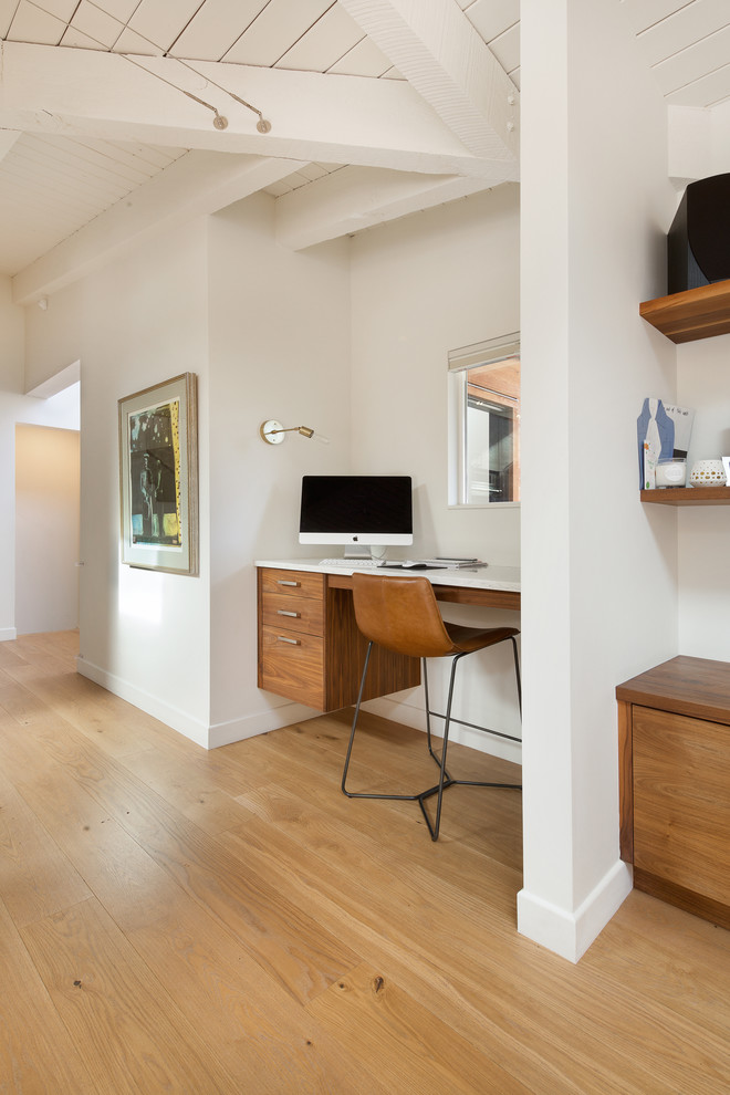 Réalisation d'un bureau vintage avec un mur blanc, parquet clair, un manteau de cheminée en plâtre et un bureau intégré.