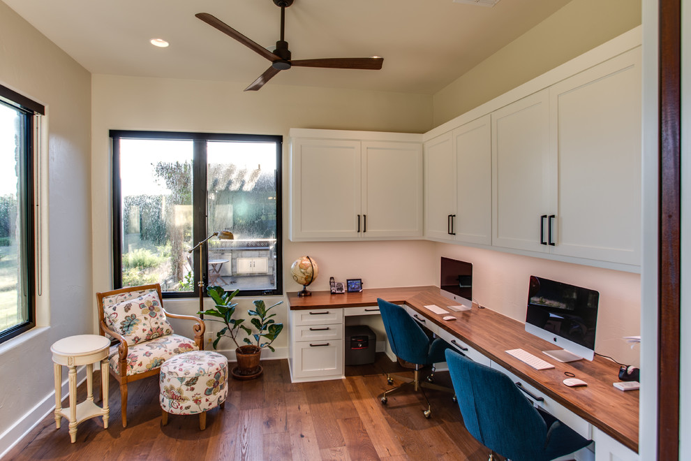 Idée de décoration pour un petit bureau champêtre avec un mur beige, un sol en bois brun, un bureau intégré et un sol marron.